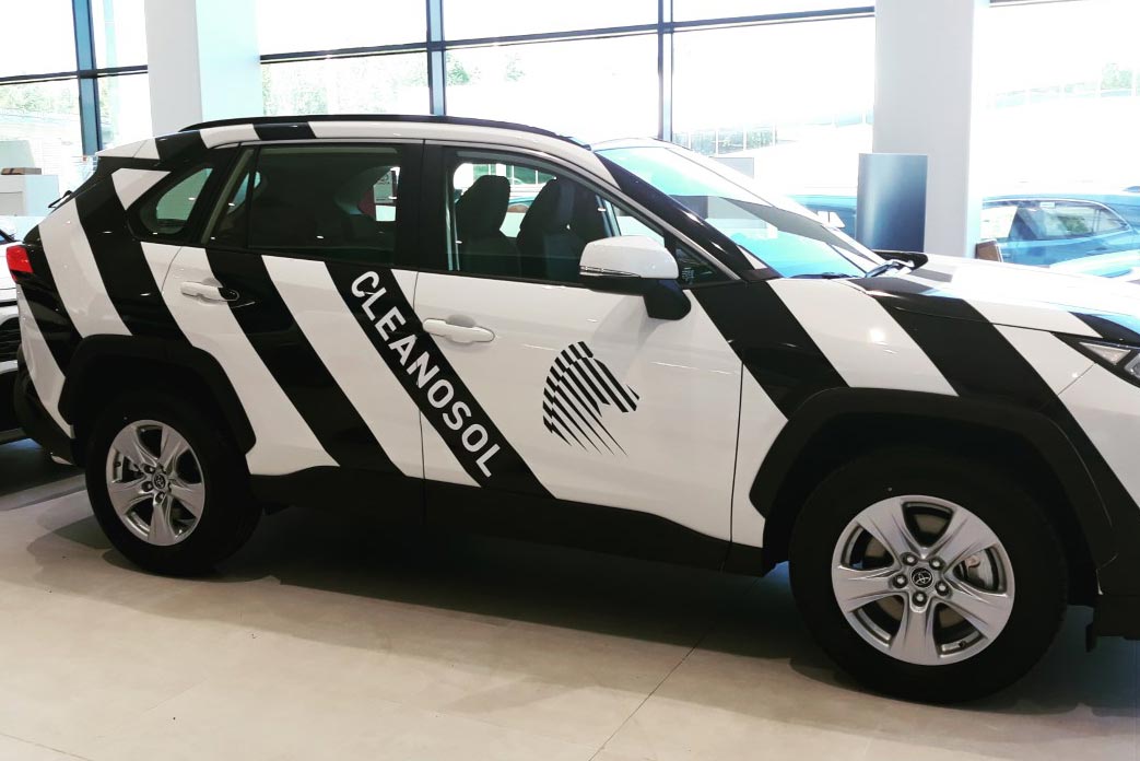 Bränditeippaus, jossa ajoneuvoon asennettu mustavalkoiset diagonaaliraidat ja logo