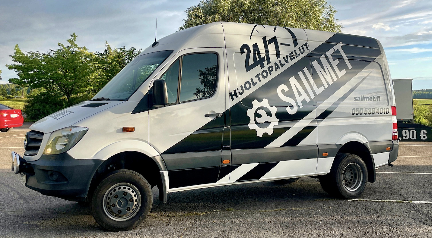 Pakettiautoteippaus, jossa yrityksen logo, palvelukuvaus ja yhteystiedot ovat esillä auton kyljessä