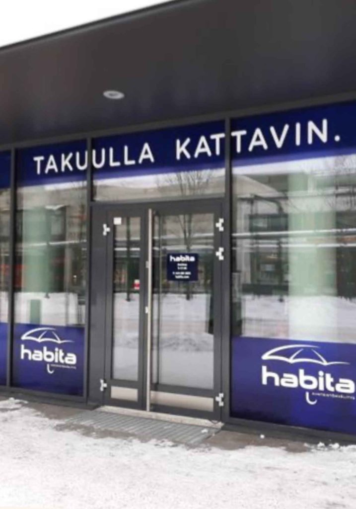 Yrityksen katutason liiketilan ikkuna, jossa on brändin mukainen ikkunateippaus logoilla ja näkösuojaa tuovilla grafiikoilla.