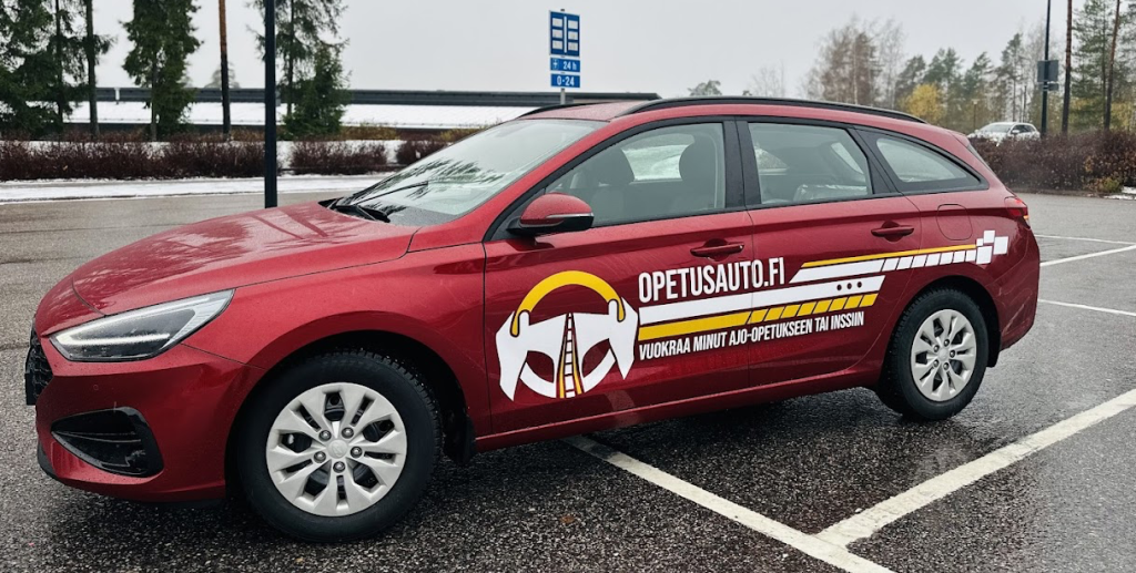 Punainen farmariauto, johon on tehty bränditeippaus. Teippauksessa yhdistyvät logografiikka ja näyttävät raidat.